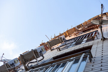 Multi-storey residential building. The front of the house is hung with air conditioning and satellite dishes. Bottom view