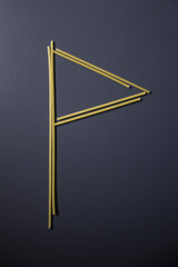 Letter 'P' written with spaghetti on gray background, top view, copy space. Food supplies, food donation on quarantine while coronavirus.