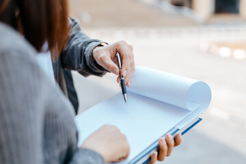 Students stand to read a book together on the campus. Education concept.