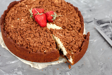 Chocolate cake is decorated with strawberry berries. Homemade cake. Pie on a grey background