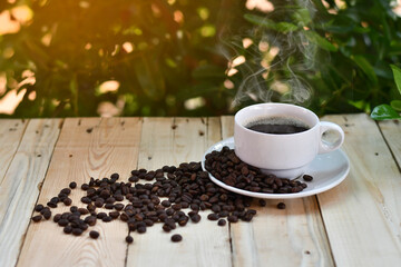 A coffee cup placed on a wooden background with a tree  bokeh