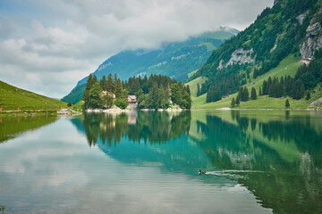 Landscape panorama from Seealpsee, Alpstein range of the canton of Appenzell, Switzerland. Green nature, mountains and their reflections on the lake.
