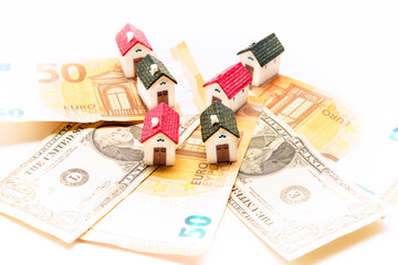 Miniature houses on euro and dollar bills