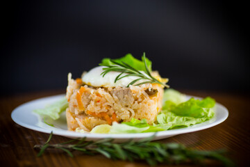 boiled rice with vegetables and fried egg with salad leaves in a plate