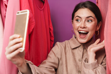 Photo of excited woman taking selfie on cellphone