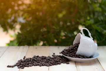 A coffee cup placed on a wooden background with a tree  bokeh