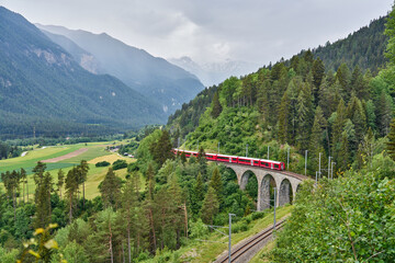 Le train rouge passe au-dessus du pont du viaduc de Landwasser, dans le canton des Grisons, en Suisse. Bernina Express / Glacier Express utilise ce chemin de fer.