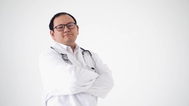 Male therapist folds his arms in front of himself, standing in a rehab center on a white hon and smiling