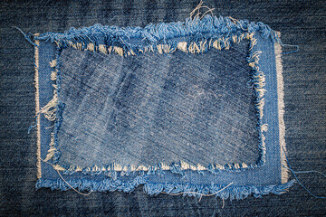 Destroyed torn denim blue jeans fabric frame on blue jeans background. Worn Jeans Casual Double...