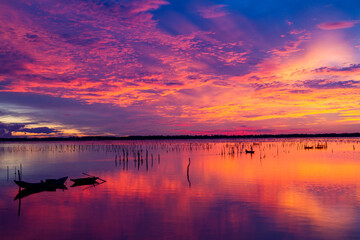 Wonderful landscape at Lap An lagoon, Vietnam with the floating house, wooden boat and amazing colorful sky of sunrise.