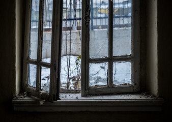 Fototapeta premium Window of an empty abandoned old building with broken glasses