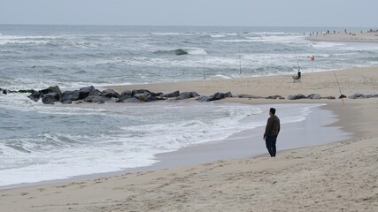 Man starring at the ocean by himself during the pandemic of COVID-19