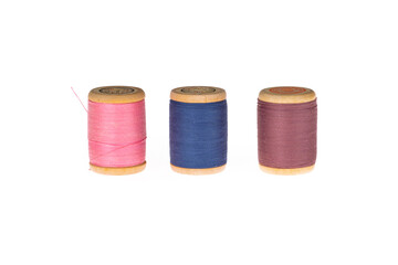Colorful thread on a wooden spool. Isolated bobbins. White  isolated background. Retro style bobbins. Close up