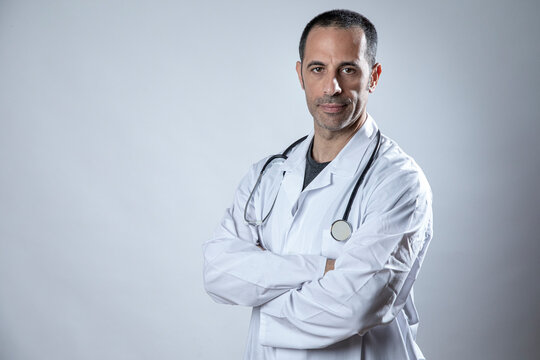 Medico scuro di carnagione con camice bianco e fonendoscopio al collo , isolato su sfondo chiaro
