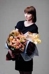 Portrait of young female florist with bouquets of flowers
