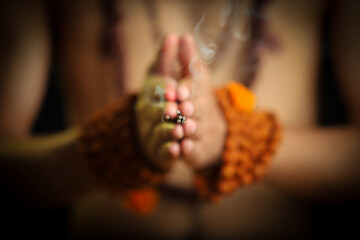 close up of a man holding a incense stick