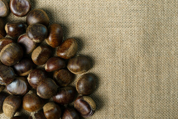 Roasted sweet chestnuts on rustic wooden table.
