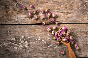 Dry bud of a tea rose in wood spoon.