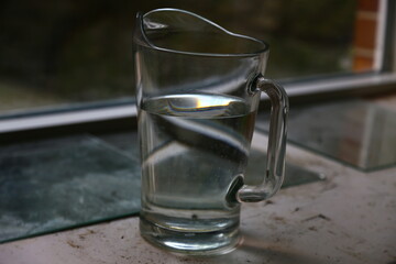 Glass pitcher with water in a large window