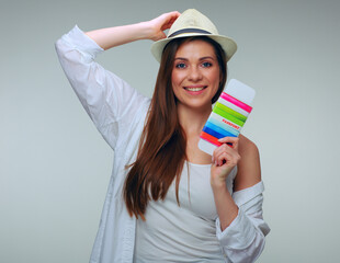 Smiling woman touching her hat holding passport.