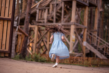 Outdoor fashion portrait of funny little  girl dancing on the street