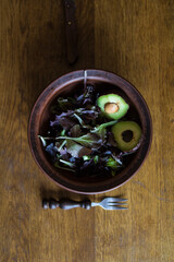 Fresh green tasty avocado lies in clay natural dishes on a wooden oak table