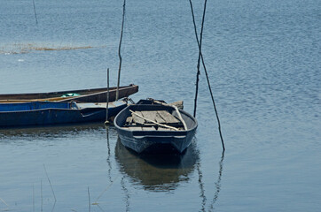 Floating fisherman boats and poles in the water