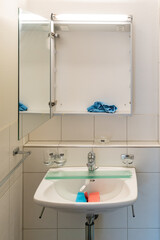 clean and bright modern bathroom with cleaning supplies on the sink