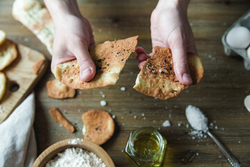 Thin italian flatbread with spices.Thin tortillas,traditional italian focaccia with olive oil and salt.Cooking process with ingredients with hands.Top view