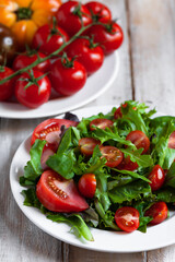 Healthy and light summer lunch: fresh green salad with ripe red tomatoes. Low calories delicious meal, vegan and vegetarian diet. Everyday source of vitamins