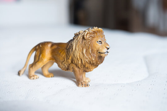 Beautiful miniature lion made of rubber or plastic. Perfect toy for children to play with. Magnificent mane. Blurred background.