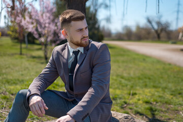 Portrait of a young bearded guy with closed eyes, from whose head a tree grows. on open air. In creative artistic toning. Business concept The birth of thoughts, ideas in the form of a growing tree.