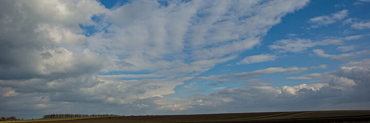 Fototapeta na wymiar plowed field and sky with clouds.
