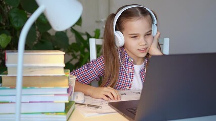 teen girl in headphones listens to lesson, distance online learning home