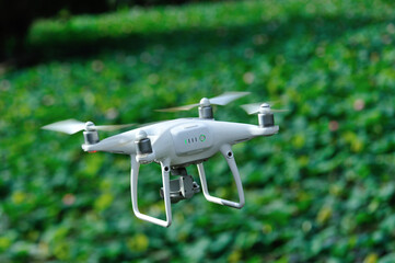 White drone with camera taking pictures of lots in the pond