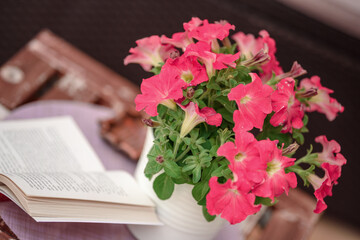 Beautiful composition with glass of water with old book and flower  on table close up