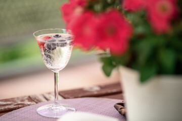 Beautiful composition with glass of water with old book and flower  on table close up