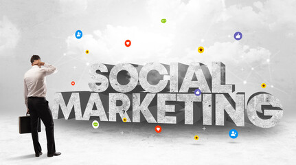 Young businessman standing in front of SOCIAL MARKETING inscription, social media concept