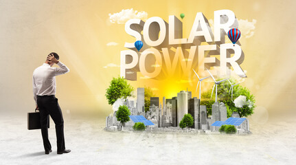 Rear view of a businessman standing in front of SOLAR POWER inscription, Environmental protection concept