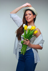 Young woman wearing hat holding tulips flowers bouquet
