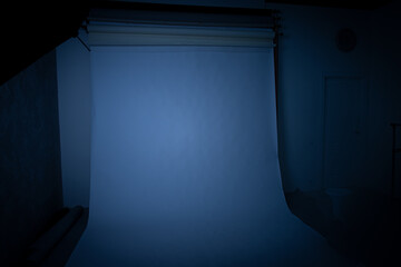 soft focus rustic dark studio environment with poor white paper background object and light turn off blue color toning horror style indoor