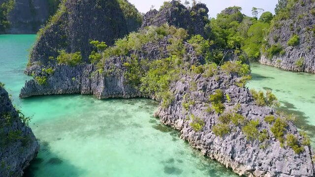 Ocean lagoon at Piaynemo islands in Raja Ampat Indonesia with beautiful turquoise waters, Aerial dolly out reveal shot