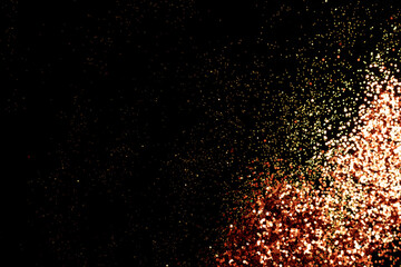 Fototapeta na wymiar Shiny golden glitter scattered on a black background. Holidays concept.