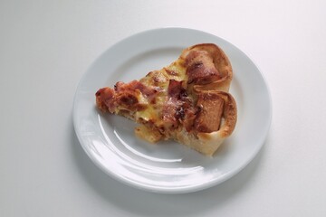 a piece of pizza placed on a white plate