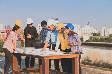 Engineer and worker team talking about project with construction site and cityscape background.