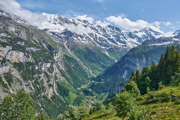 Fototapeta na wymiar Swiss Alps landscape panorama of Lauterbrunnen valley with green nature and snowy mountains. Taken near Mürren, Bernese Highlands, canton of Bern, Switzerland 