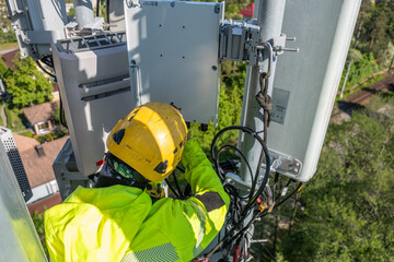 Cell phone installers work on the tower