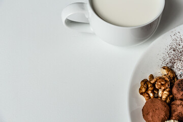 a delicious dessert of chocolate truffles and a cup of fresh milk, dried fruit truffles, healthy and very tasty