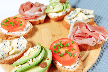 Traditional Italian bruschetta with various topping - cheese, prosciutto and vegetables.