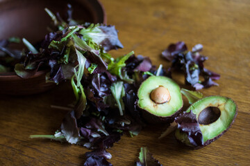 Obraz na płótnie Canvas Fresh green tasty avocado lies in clay natural dishes on a wooden oak table 